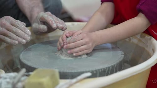 Pottery workshop. A man teaching a child the art of pottery.