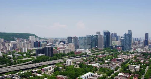 Aerial tracking shot in front of the skyline of sunny Montreal, Quebec, Canada