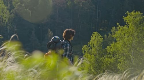 Young Female Tourist Walking down to River while Hiking