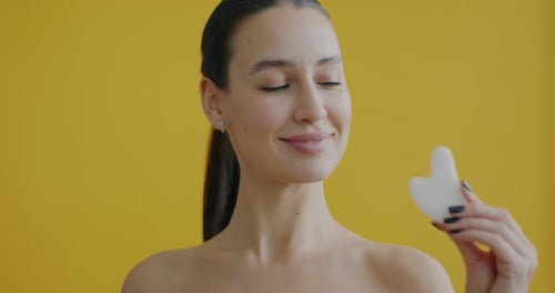 Woman Holding Gua Sha and Jade Roller