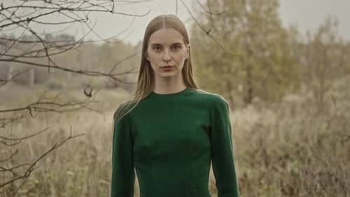Model posing in green dress in autumn field