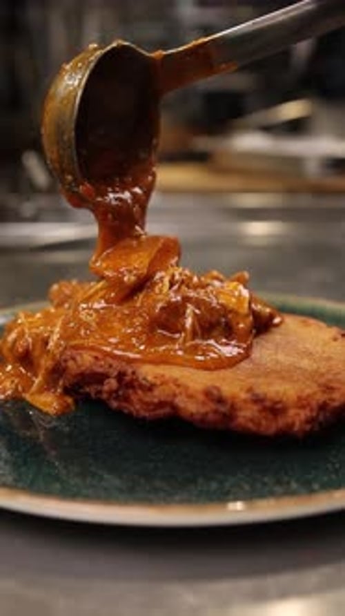Pouring Savory Sauce Over Delicious Potato Pancake