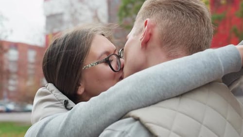 Close Up of Couple Kissing Affectionately While Hugging Outdoors in Casual Wear