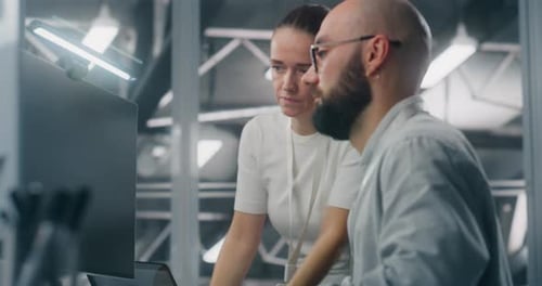 Man and Woman Collaborating on Computer Project