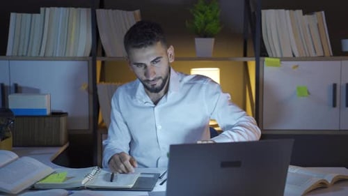 Man Studying at Desk at Night