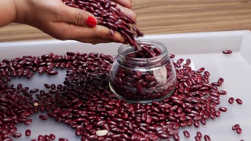 Pouring Red Kidney Beans Into Glass Container