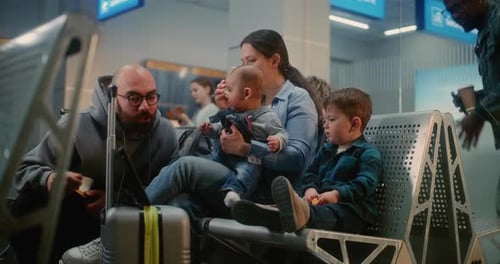 Boarding Lounge of Airline Hub Woman with Two Little Children Waiting for Airplane Flight