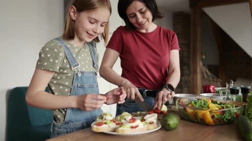 Mother and Daughter Preparing Food Together in Kitchen