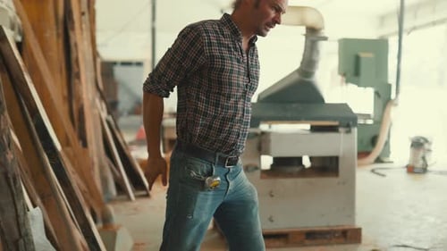 Carpenter Selecting Wooden Boards in a Joinery Workshop