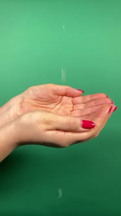 Water Cascading onto Cupped Hands on Green Screen