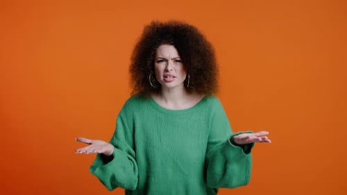 Annoyed Woman Gesturing on Orange Background