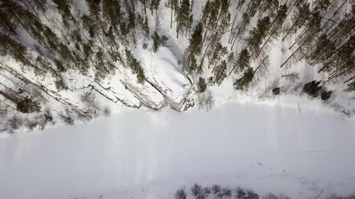 A Snow Covered Forest with a Winding River in a Beautiful and Tranquil Winter Landscape Stock Clip