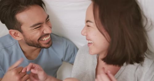 Happy, playing and couple games in a bedroom with man and woman laugh and having fun in bed