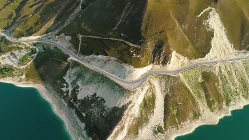 Aerial Over the Roadway Along Lake Kezenoyam with Turquoise Water and Tall Mountains Stunning
