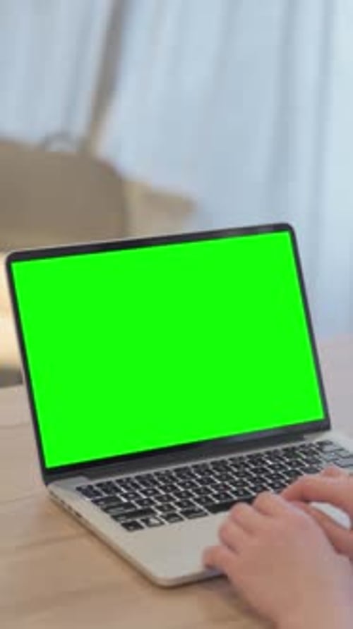 Young Woman Using Laptop with Green Screen, vertical video