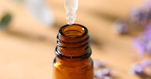 Dropper Adding Herbal Essence to Small Bottle Close-up
