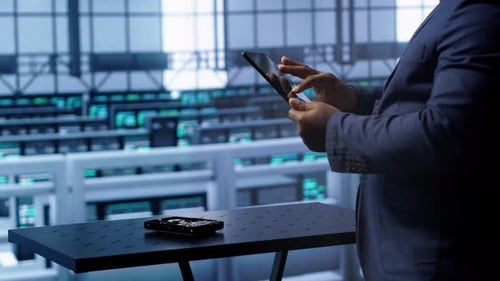 IT Expert in Data Center Holding Tablet Replacing Storage Mainframes Components