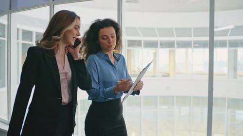 Professional Women Discuss Business in a Modern Office