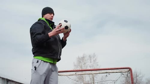 Young Man Holding a Soccer Ball Outdoors