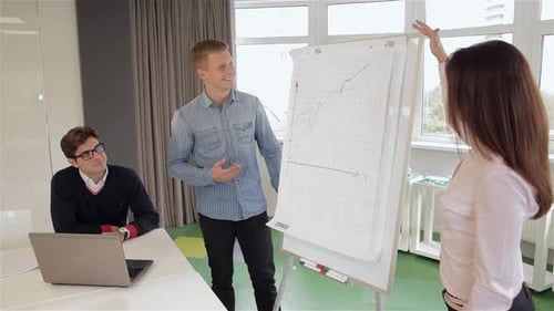 Woman Explaines the Chart to Her Colleague at the Office