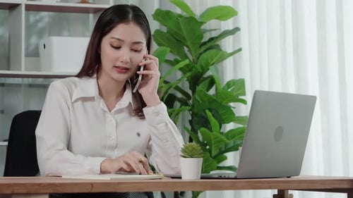 Woman Working From Home on Phone at Desk