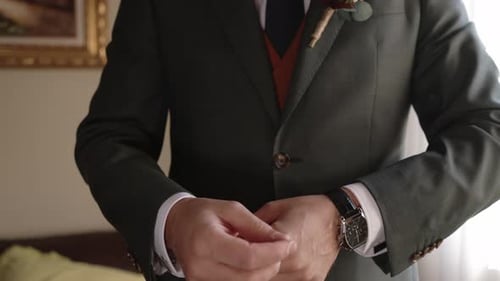 Man Adjusting Cufflinks on Formal Suit Indoors