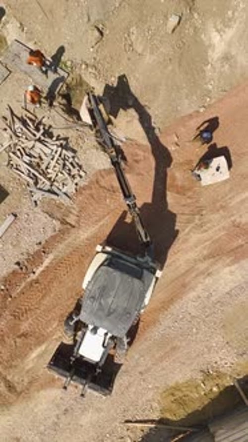 Vertical Video Ground Clearing Aerial View of Tractor Preparing Site for Housing Complex