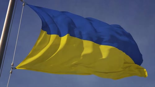 Blue and Yellow Flag Waving on a Pole Against a Clear Sky