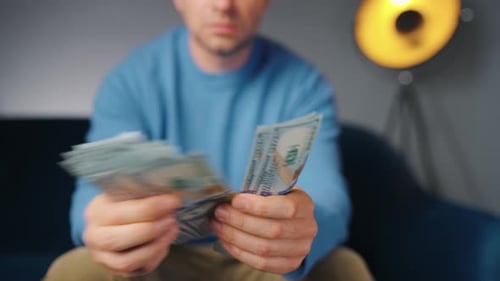 Man Counts Stack of United States Currency