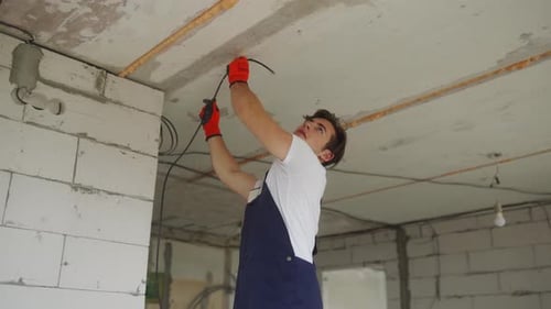 Construction Worker Wiring in an Unfinished House