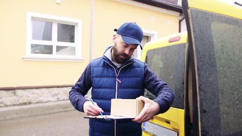 Delivery man handing a parcel box to a recipient on a suburban street
