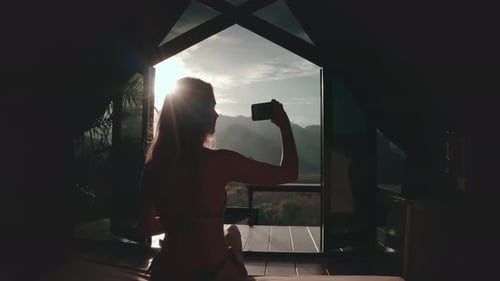 Woman Taking a Photo of the Sunset From a Thailand Resort