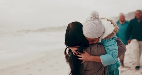 Family Embrace on Sandy Beach on Overcast Day