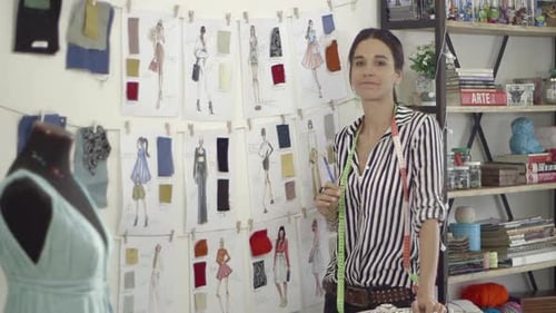 Young female fashion designer working at home studio.