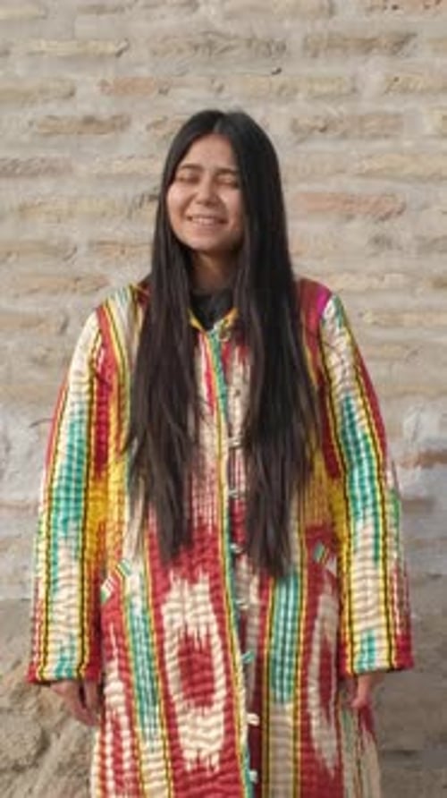 Smiling Woman in Colorful Robe Standing Outdoors