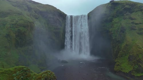 Majestic Waterfall Cascading Down Green Rocky Cliffside