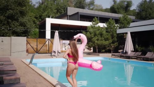 Pretty Model in Pink Bikini and Sunglasses Walking and Posing By Swimming Pool with Clear Blue Water