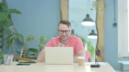 Man Smiling and Waving During Video Conference