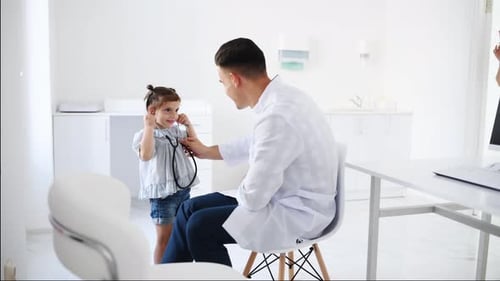Friendly Doctor Guiding Child with Stethoscope in Clinic