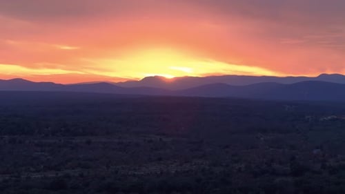 Beautiful picturesque sunset over mountainous horizon with wild terrain