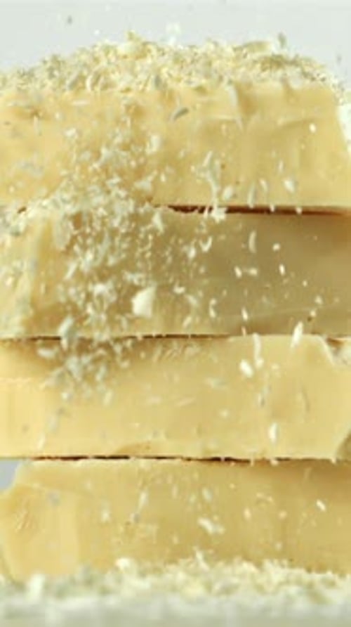 Shredded White Chocolate Falls on a Tower of Chocolate Pieces Filmed on a Highspeed Camera at 1000
