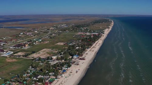 Beautiful flight in summer over the beach. People are resting near the sea. Houses for tourists.