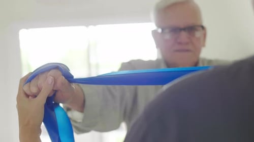 Senior Man Exercising with Resistance Band at Home