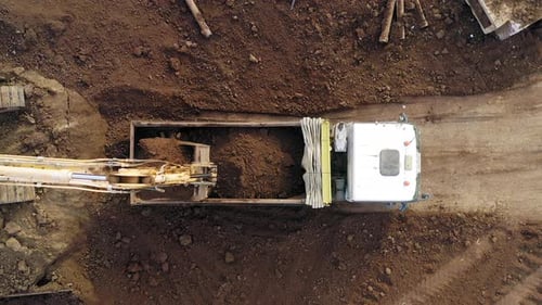 Excavators loading soil onto Trucks, Aerial view.