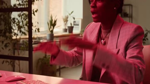 Woman Typing at Office Desk with Red Lighting