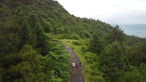 Drone Fly Over Tourist Walking on a Paved Road in the Tropical Mountain