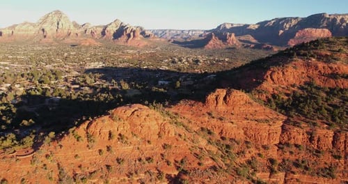Aerial View of Sedona Arizona USA, Buildings and Homes in Valley Under Red Hills on Sunny Morning