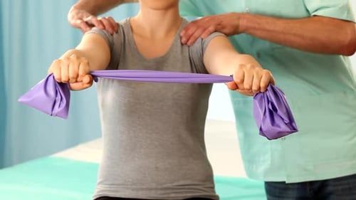 Woman doing arm exercises with therapist in hospital