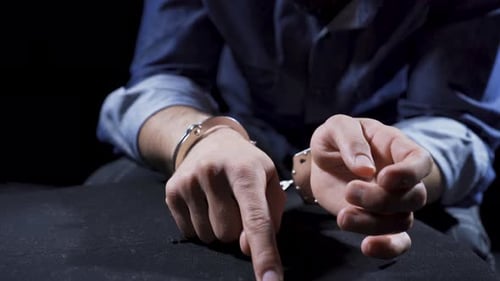 Man in Handcuffs at Table