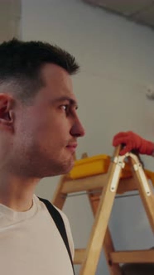 Close Up View of the Handsome House Painter with the Stain of White Paint on His Forehead Looking